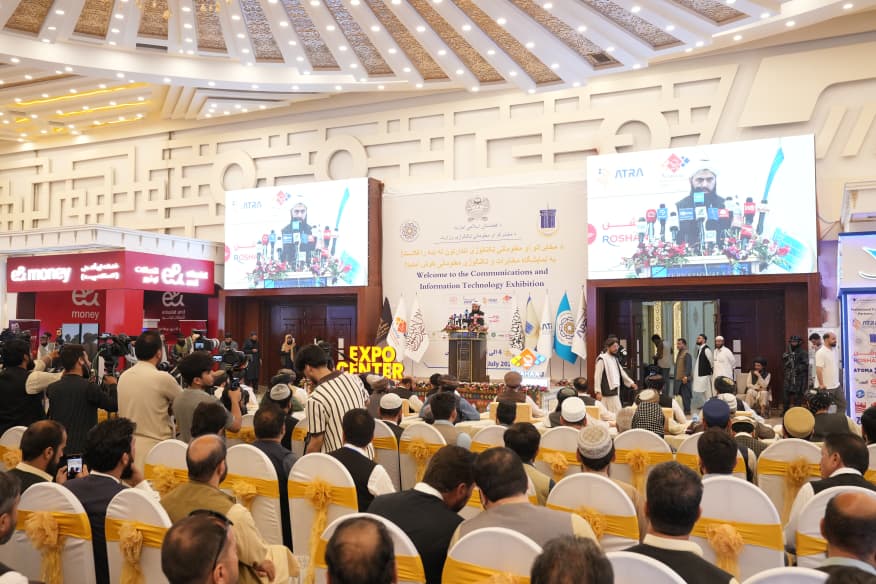 Opening ceremony of an exhibition in Kabul with the audience facing the main stage and screens