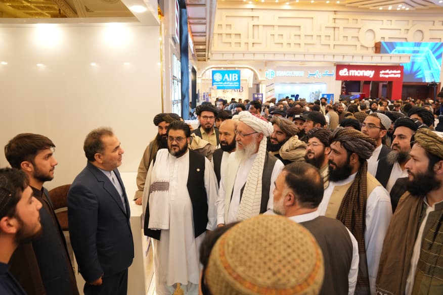 Officials and visitors touring exhibitor stands during an exhibition