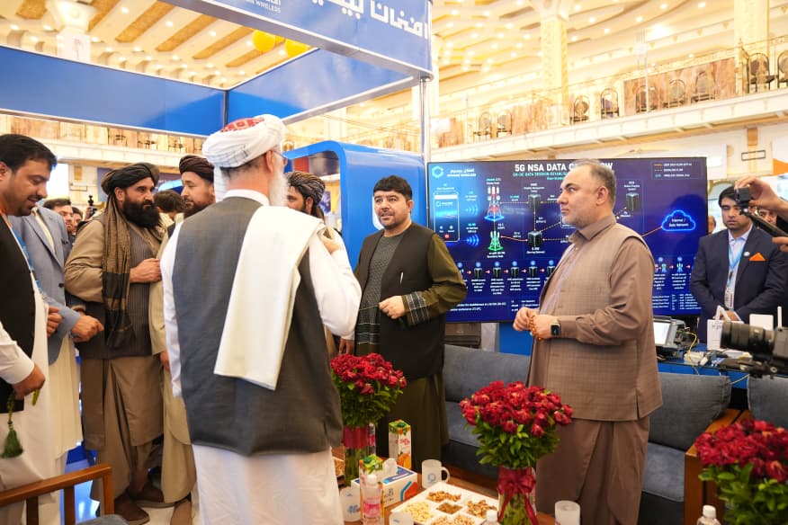 Business conversation at a technology exhibitor stand during an exhibition