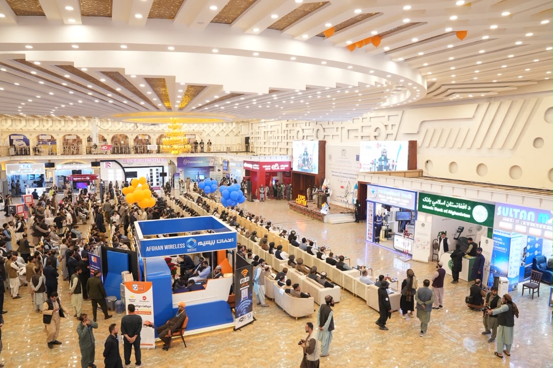 Wide view of a full exhibition hall in Kabul with exhibitor stands and visitors